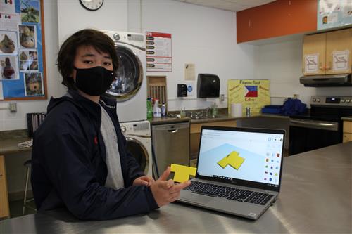 Boy wearing mask holds up yellow piece