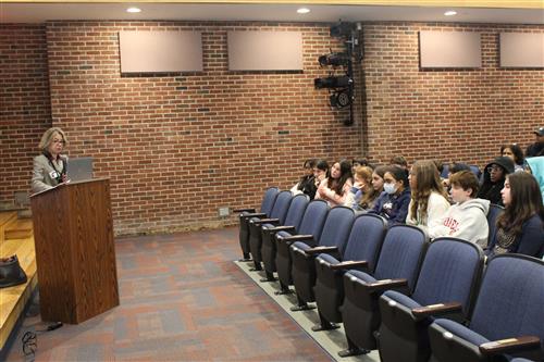 Woman talking to students in an auditorium