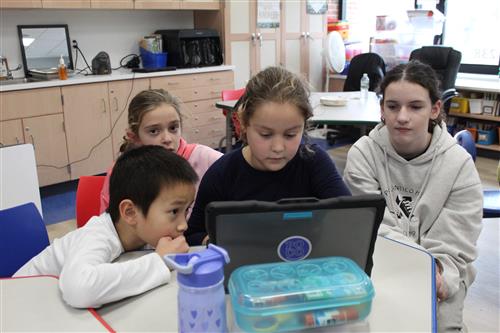 Student gathered around a computer