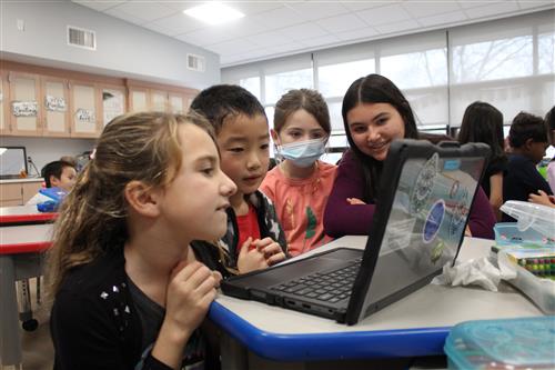 Students gathered around a computer