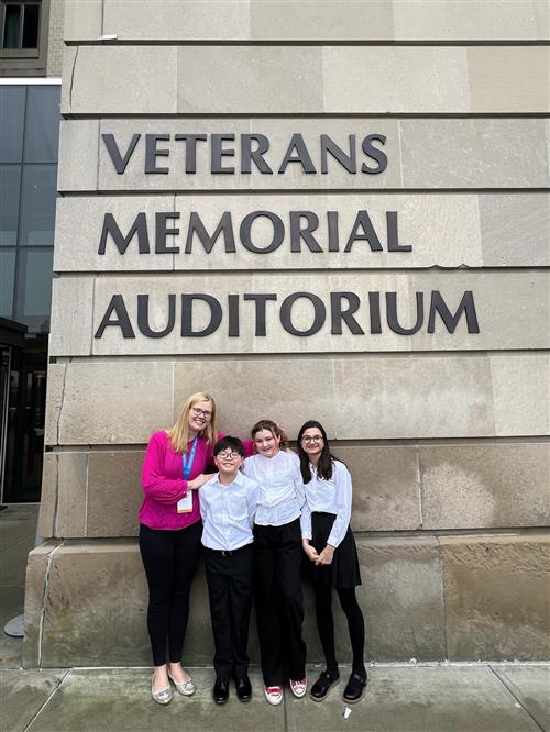 Students and teacher outside auditorium