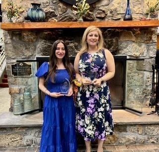 Two women holding awards