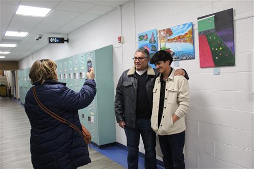 Woman takes photo of boy in front of art